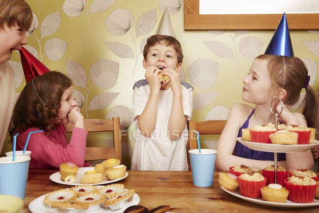 Crianças comendo comida de festa na festa de aniversário — Fotografia de Stock