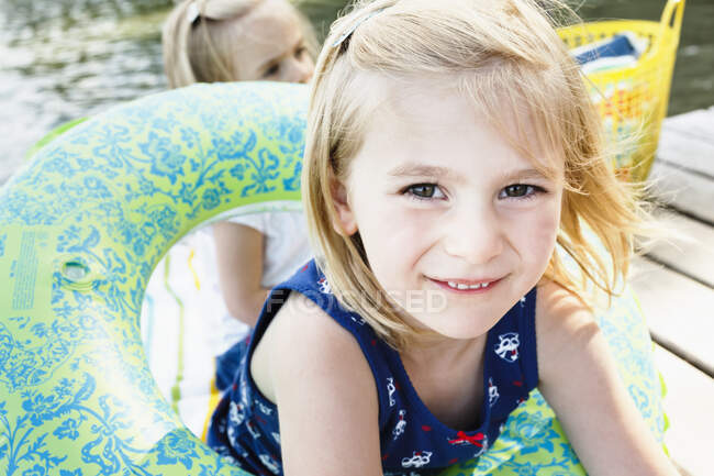 Porträt eines süßen Mädchens, das mit einem aufblasbaren Ring auf einer Seebrücke am Starnberger See spielt — Stockfoto