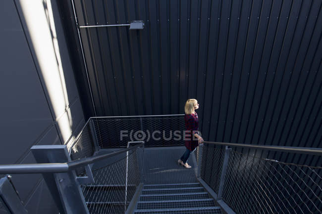 Side view of Woman walking down stairway — Stock Photo