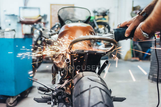 Hombre maduro, trabajando en moto en garaje - foto de stock