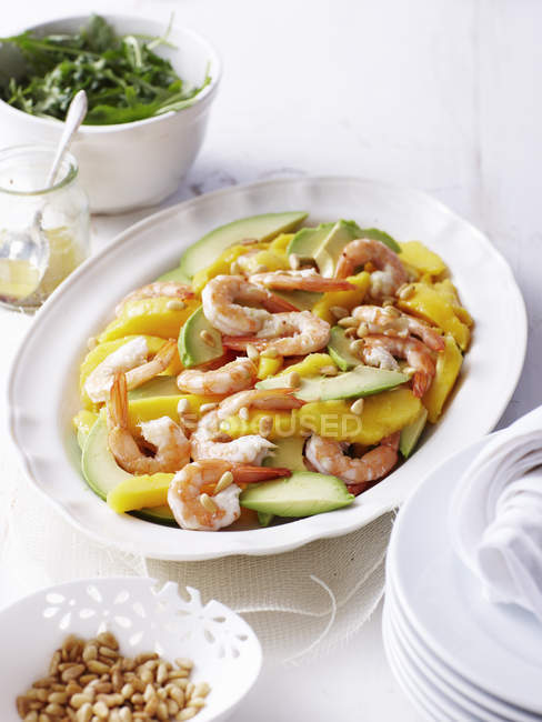 Salad dish with prawns, avocado, mango and pine nuts — Stock Photo