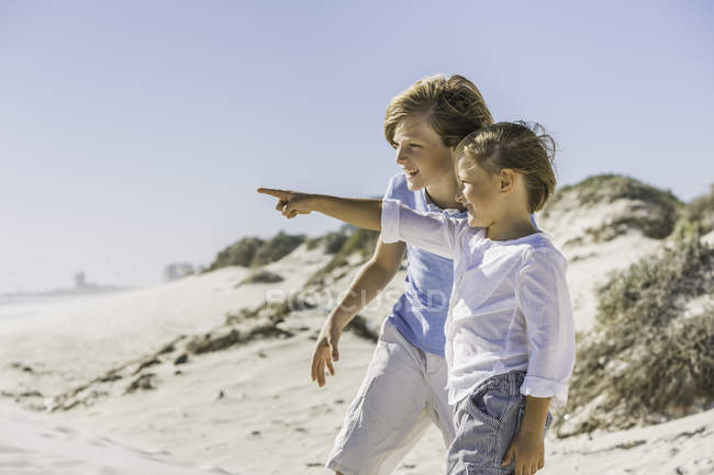 Brothers pointing on sea on beach — Stock Photo