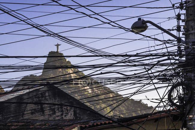 View of Christ Redeemer statue through telegraph wires and cables, Rio De Janeiro, Brazil — Stock Photo