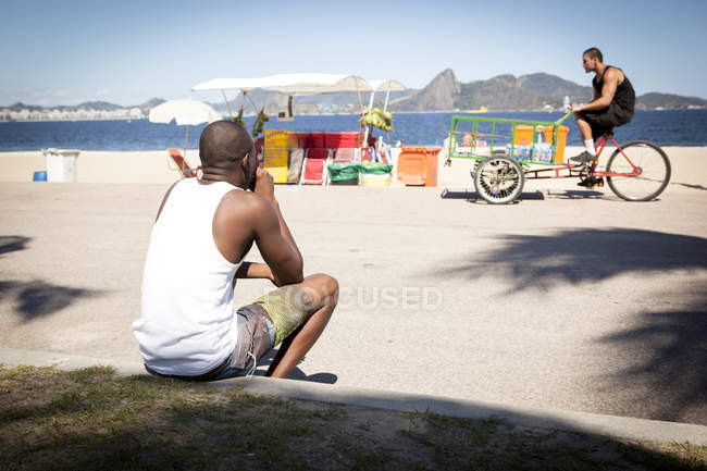 Чоловік спостерігає води продавця на велосипеді — стокове фото