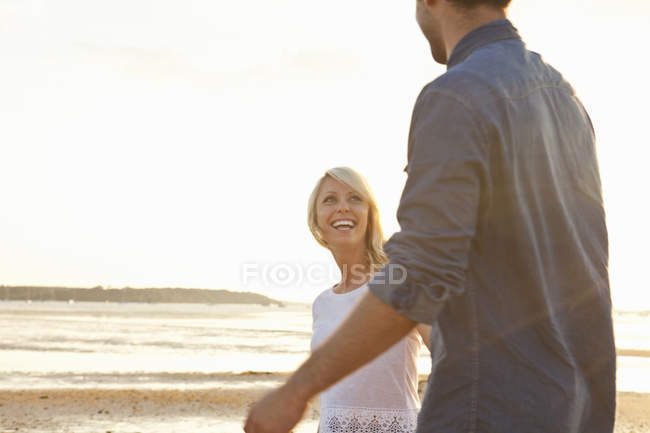 Jovem casal desfrutando de praia ensolarada — Fotografia de Stock