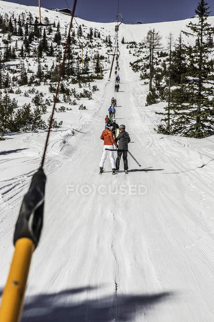 Esquiadores no elevador de esqui, visão traseira — Fotografia de Stock