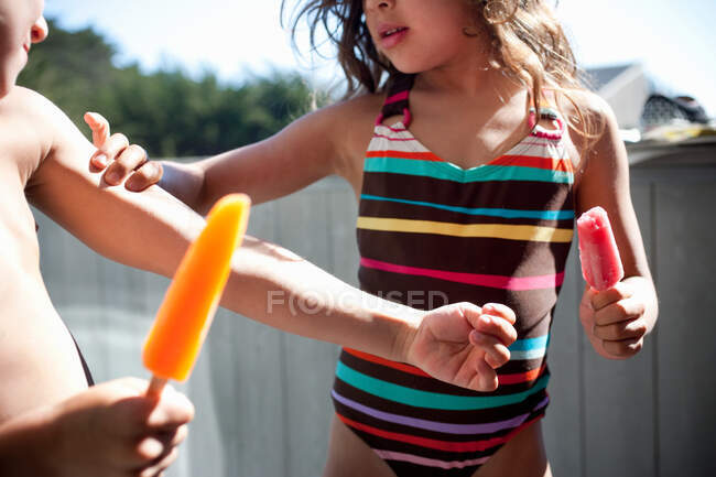 Enfants mangeant des sucettes de glace — Photo de stock