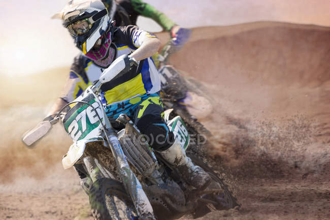 Two young male motocross riders racing on muddy track — Stock Photo