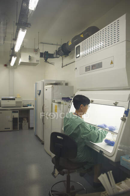 Scientist working behind screen of scientific machine — Stock Photo