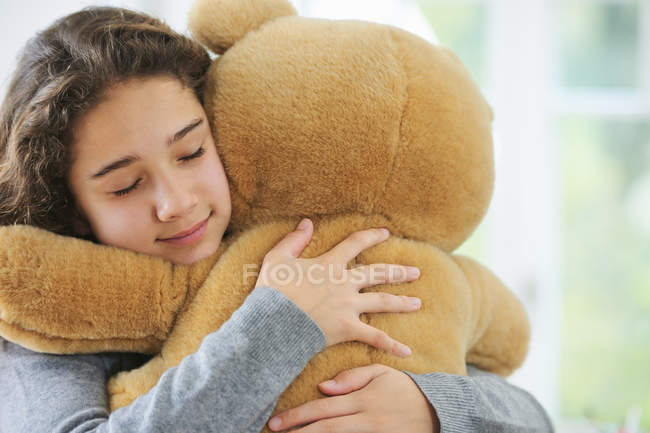Portrait of young girl hugging teddy bear — Stock Photo