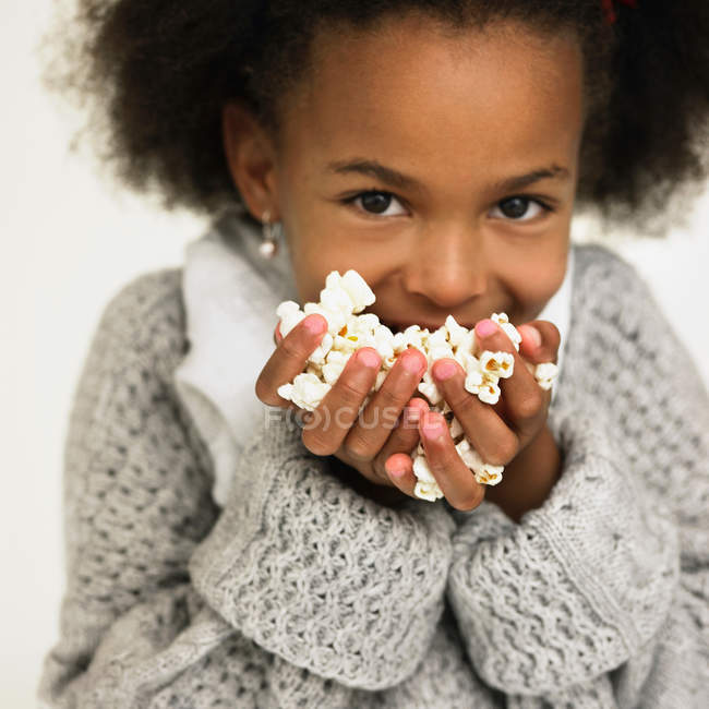 Дівчина їсть жменьку попкорну — стокове фото