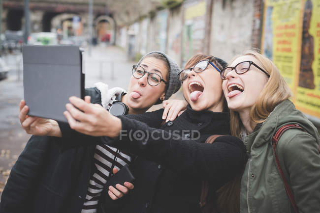 Three sisters taking selfie on street — Stock Photo