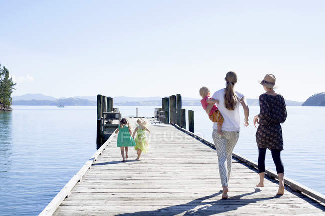 Deux femmes et filles adultes se promènent sur un quai, en Nouvelle-Zélande — Photo de stock