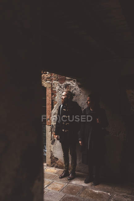 Couple looking out from darkened doorway, Venice, Italy — Stock Photo