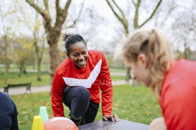 Mujeres futbolistas adultas preparándose para jugar fútbol en el parque - foto de stock