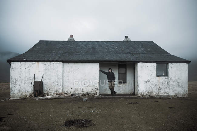 Hiker leaning against wall of shelter house at Camasunary Bothy in Scottish Highlands, Isle of Skye, Scotland — Stock Photo