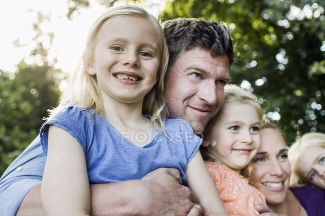 Portrait of parents and three young daughters in park — Stock Photo