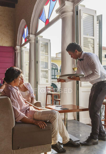 Young couple being served wine in restaurant, Havana, Cuba — Stock Photo