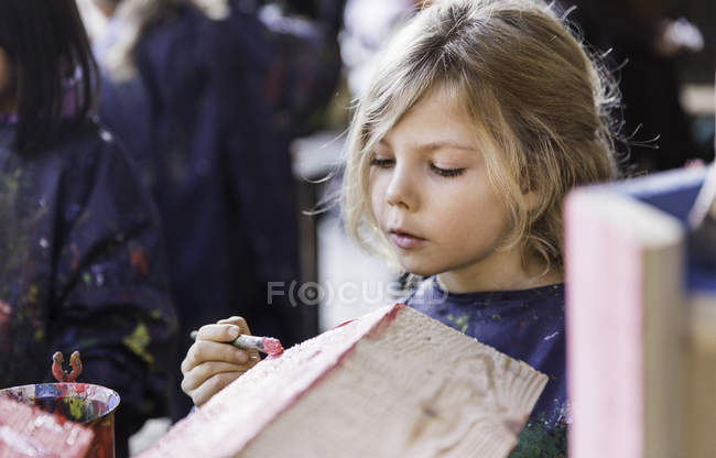 Elementary idade menina pintura de madeira casa — Fotografia de Stock