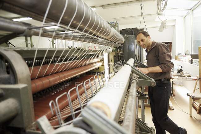 Trabajador que utiliza la máquina en fábrica de lana - foto de stock