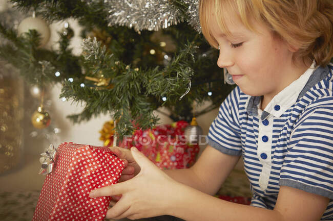 Niño sosteniendo regalo de Navidad - foto de stock