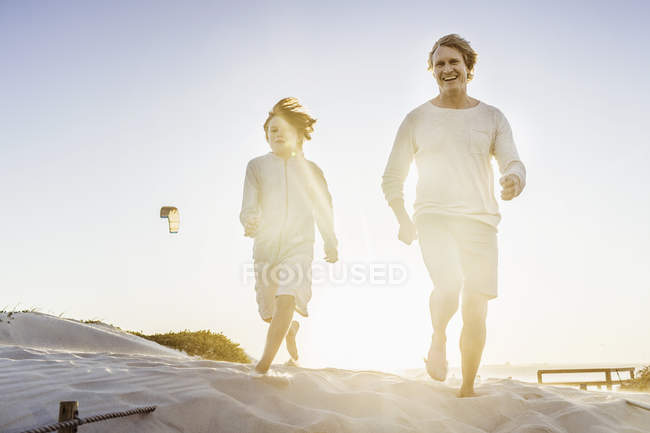 Padre e hijo caminando en la playa - foto de stock