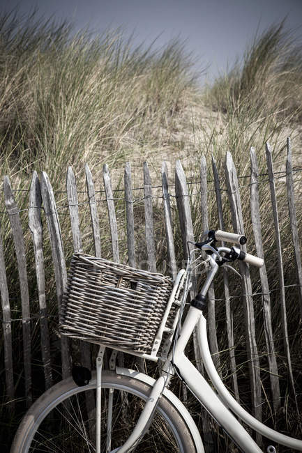 Close up de bicicleta contra cerca de duna de areia — Fotografia de Stock