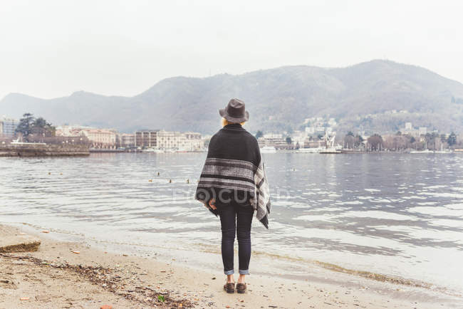 Rückansicht einer stilvollen jungen Frau mit Blick vom Seeufer, Comer See, Italien — Stockfoto