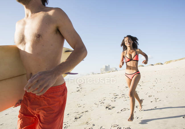 Young surfing couple running down beach, Cape Town, Western Cape, South Africa — Stock Photo