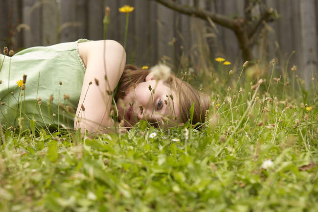 Ragazza sdraiata sul giardino erba sognare ad occhi aperti — Foto stock