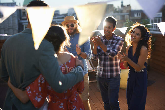 Friends congratulating couple at early evening engagement party — Stock Photo