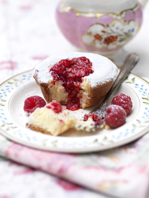 Тарелка сахарной пудры малиновый пирог на столе — стоковое фото