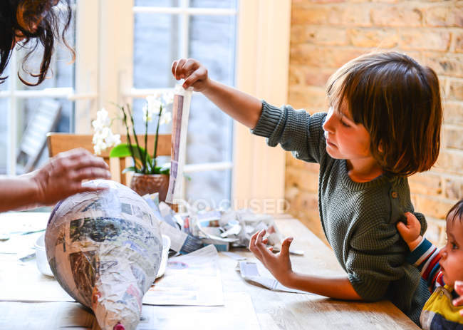 Niño y madre jugando con papier mache - foto de stock
