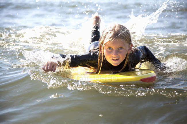 Портрет девушки на доске для серфинга, Уэльс, Великобритания — стоковое фото