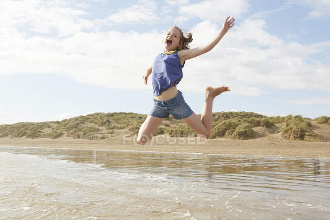 Mädchen springen mitten in der Luft am Strand, Camber Sands, kent, uk — Stockfoto