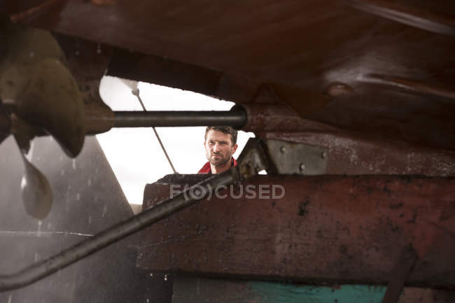Male ship painter using pressure washer to clean ship hull — Stock Photo