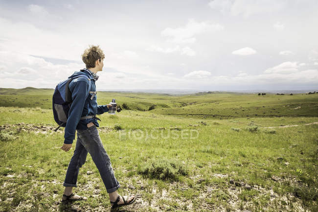 Senderismo adolescente masculino en el paisaje, Cody, Wyoming, Estados Unidos - foto de stock