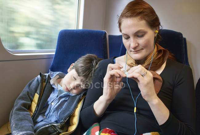 Madre e hijo dormido sentado en el tren en movimiento - foto de stock