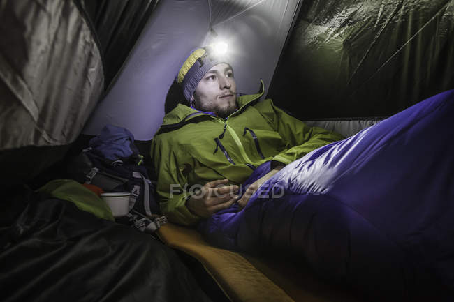Young male hiker in tent on Klammspitze mountain, Oberammergau, Bavaria, Germany — Stock Photo
