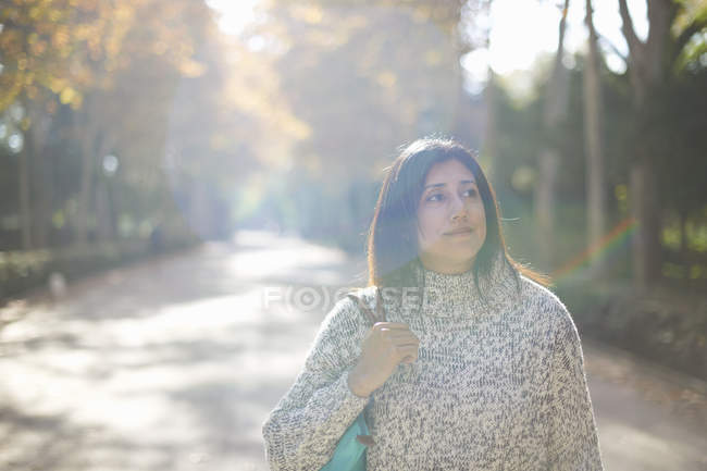 Mujer madura en camino arbolado, mirando hacia otro lado, Sevilla, España - foto de stock