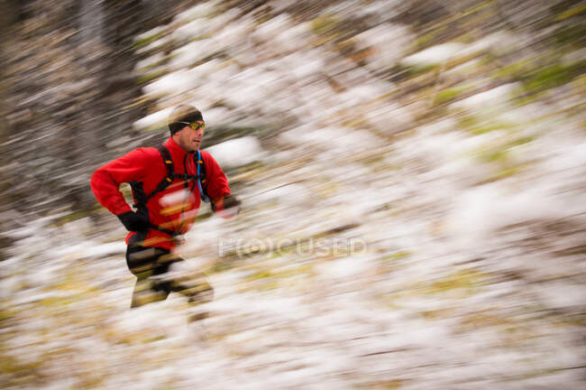 Vista borrosa del hombre corriendo en la nieve - foto de stock