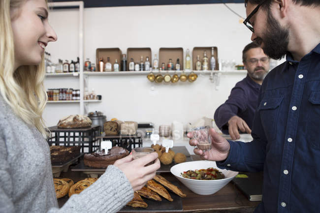 Kellner serviert Paar, das Espresso an Café-Theke trinkt — Stockfoto