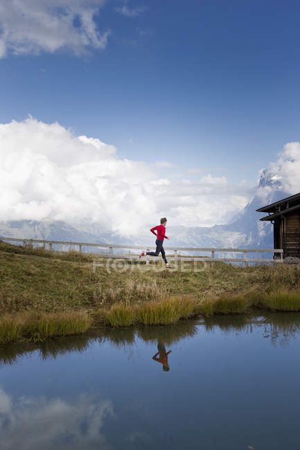 Мужчина бежит вдоль озера, Кляйн Шейдегг, Гриндельвальд, Швейцария — стоковое фото