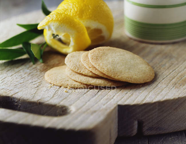 Lemon shortbread thins on vintage wooden cutting board — Stock Photo