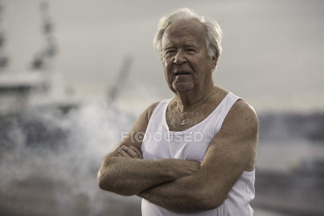 Man wearing vest, arms crossed, looking at camera — Stock Photo