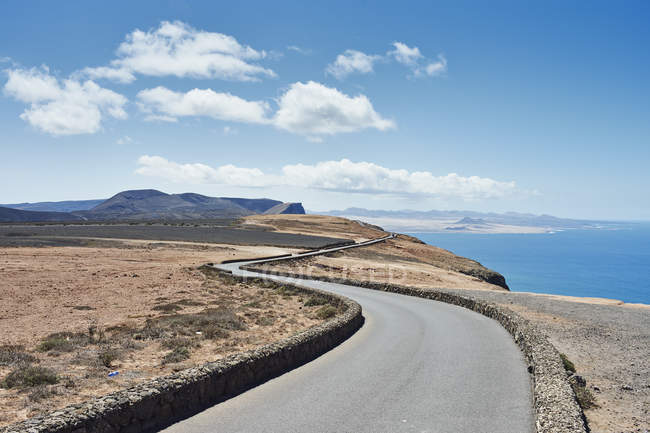 Estrada costeira ondulada com paisagem oceânica, Lanzarote, Espanha — Fotografia de Stock