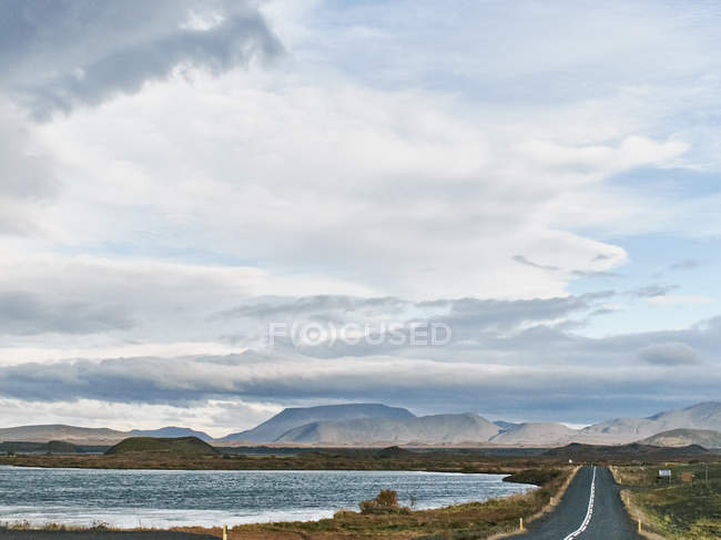 Montanhas distantes e estrada rural pelo Lago Myvatn, Islândia — Fotografia de Stock