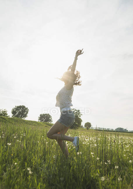 Jeune femme sautant dans le champ — Photo de stock