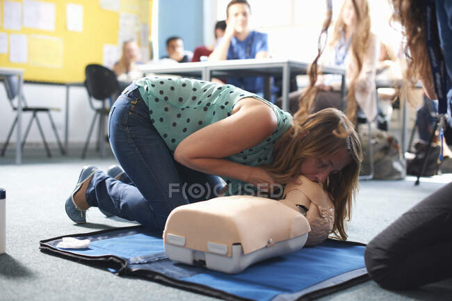 Estudante universitário realizando RCP em manequim em sala de aula — Fotografia de Stock