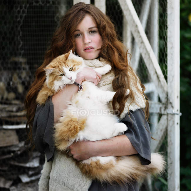 Woman holding large cat outdoors — Stock Photo